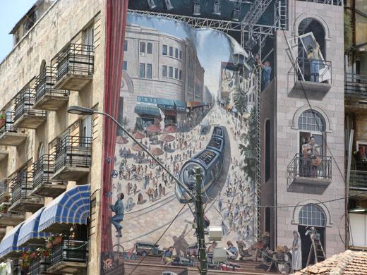 mural on a building in Jerusalem showing the light rail