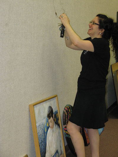 Jill pulls the wire to hook up a painting.