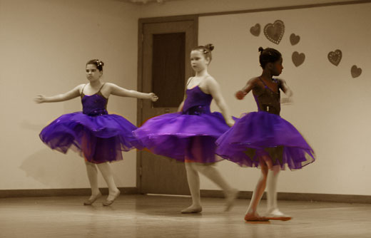 ballet dances in purple dresses with sepia background