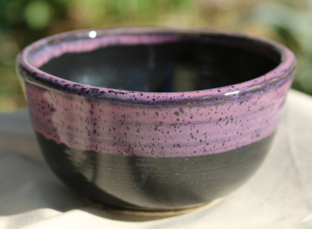 Bowl with black and pink glazes. Speckled clay.