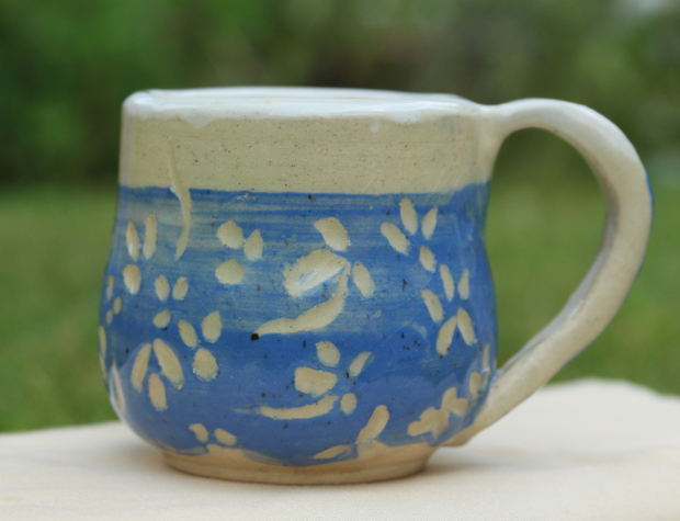 Mug with blue slip flowers. White clay with clear and white glazes.