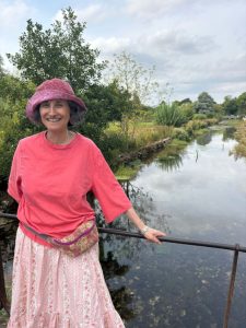 Bucket hat, salmon t-shirt, elastic waist skirt with pockets, fanny pack (photo taken in Bibury, Cotswolds, UK)