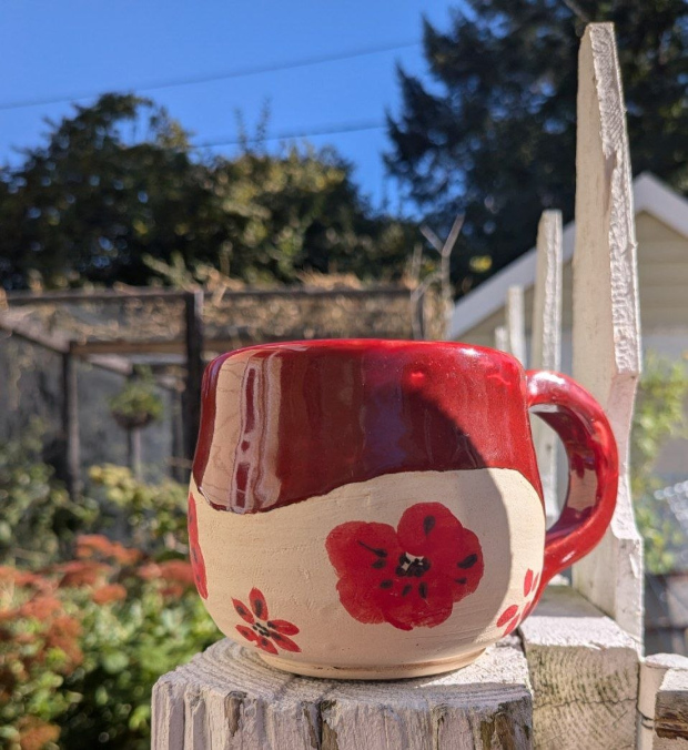 Red mug with poppies. Eggplant and bright red glazes. Red and black underglazes.